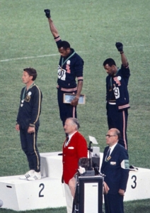 John Carlos, Tommie Smith og Peter Norman,, der bar et "Olympic Project for Human Rights" badge til støtte for de to førstnævntes protest. support of their gesture. http://www.gettyimages.co.uk/detail/news-photo/the-american-sprinters-tommie-smith-john-carlos-and-peter-news-photo/186173327 Author Angelo Cozzi (Mondadori Publishers)