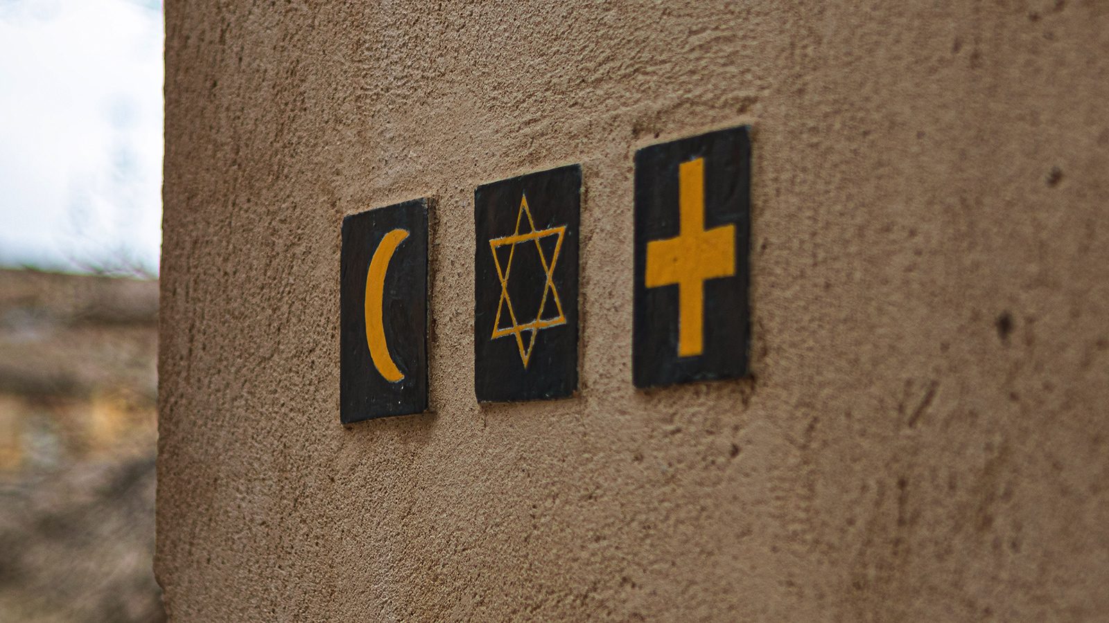 Symboler for islam, jødedom og kristendom på en væg