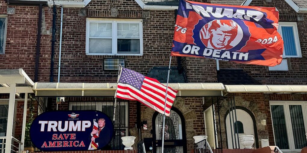 Et foto af et amerikansk rækkehus, hvor Trump flag og banner med teksten Trump eller død vejer.