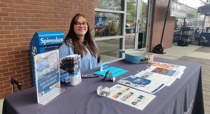 Fernanda Pineda sidder bag et bord med en blå dug og forskellige flyers om udveksling. Hun vender tilbage til Chile inden for et halvt år og kunne ikke stemme ved valget i USA. 