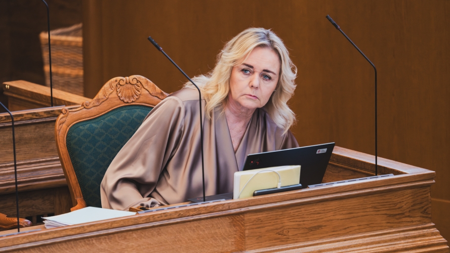 Foto af Mona Juul, med et skuffet udtryk, på sin plads i folketinget.