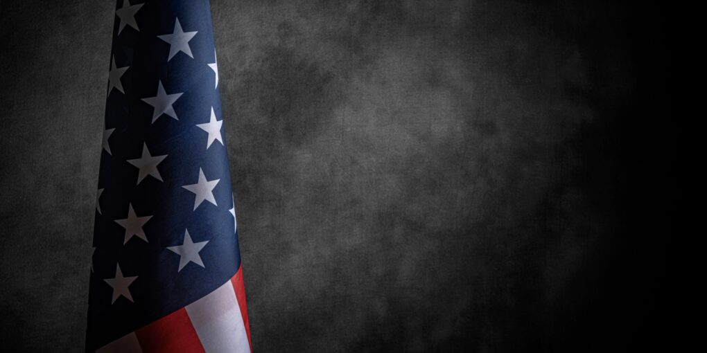 Foto af det amerikanske flag, ikke udspilet, med mørk baggrund.