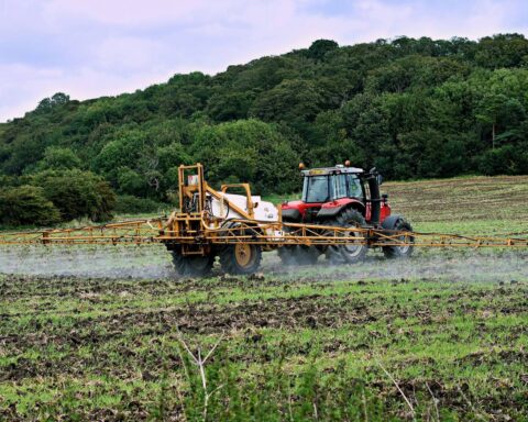 Foto af traktor med spray på landbrugsjord.