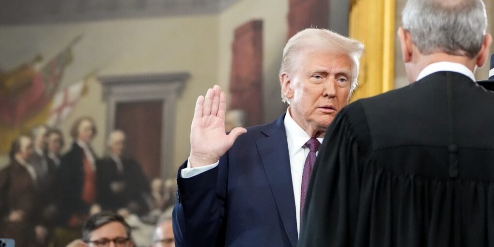 Foto af Trump, der hæver højre arm, da han aflægger ed ved sin indsættelse.