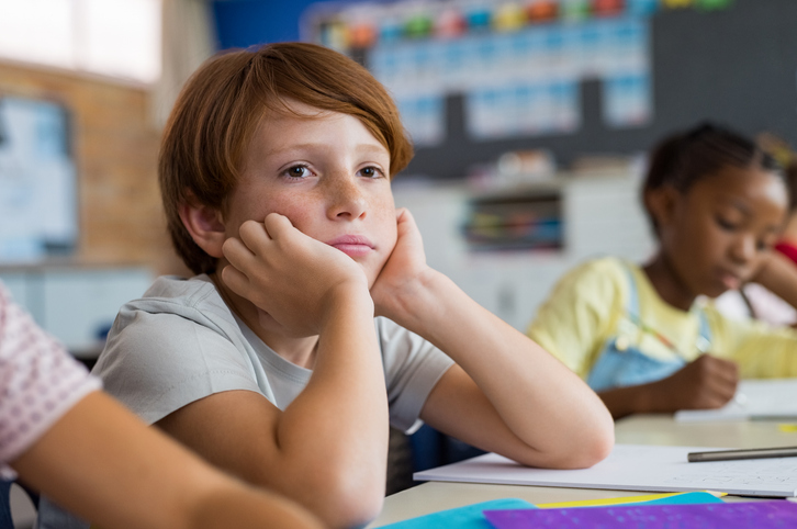 Foto af dreng, der keder sig i skolen