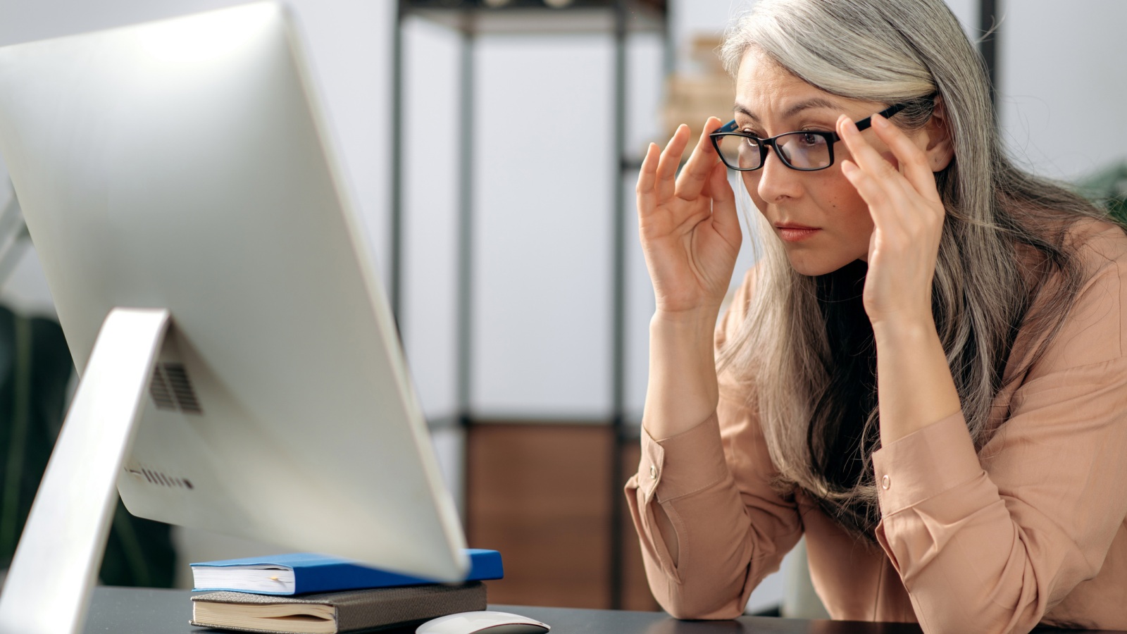 Kvinde, der på computeren tjekker sin årsopgørelse eller sin omkostningsrapport for at se, hvilke gebyrer er blevet betalt.