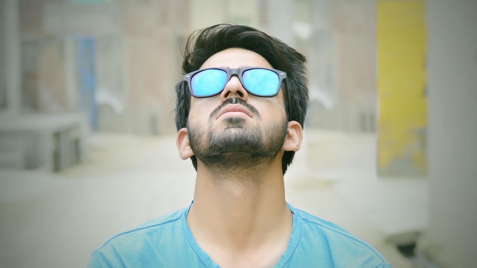 En voksen mand, der ser opgivende ud, men skjuler sig bag solbriller.