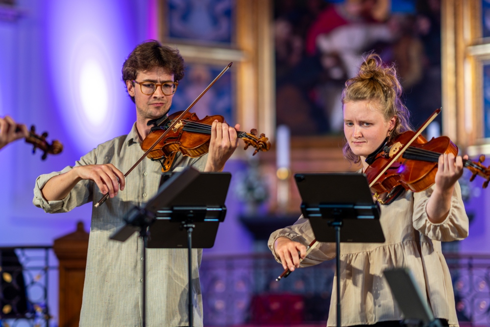 To musikere optræder med violinspil.