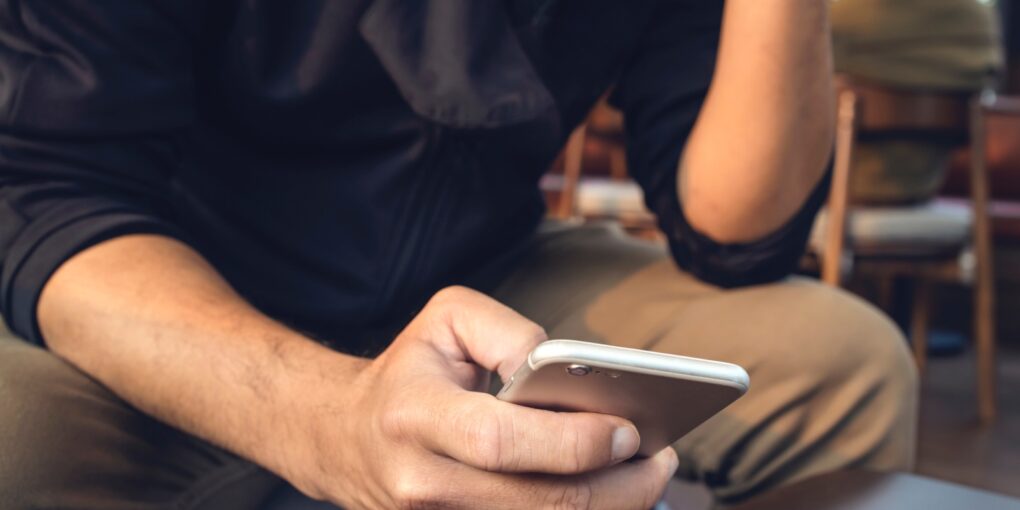 Foto af en person med telefon i hånden som illustration af sociale medier, der tager over.