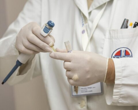 En læge der har handskerne på - som et billede på at være på afstand af kvinders sundhed.