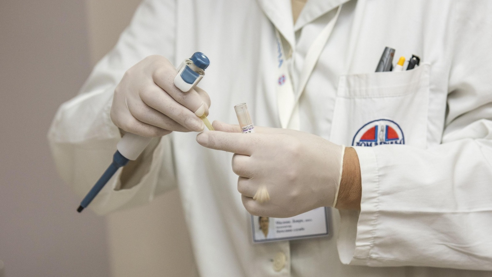 En læge der har handskerne på - som et billede på at være på afstand af kvinders sundhed.