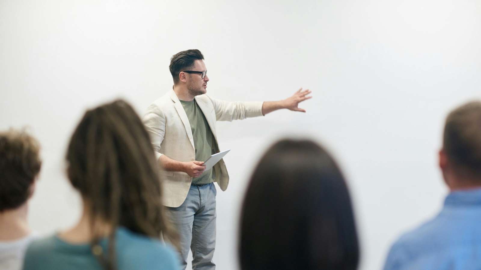 Et foto af en lærer foran nogle gymnasieelever.