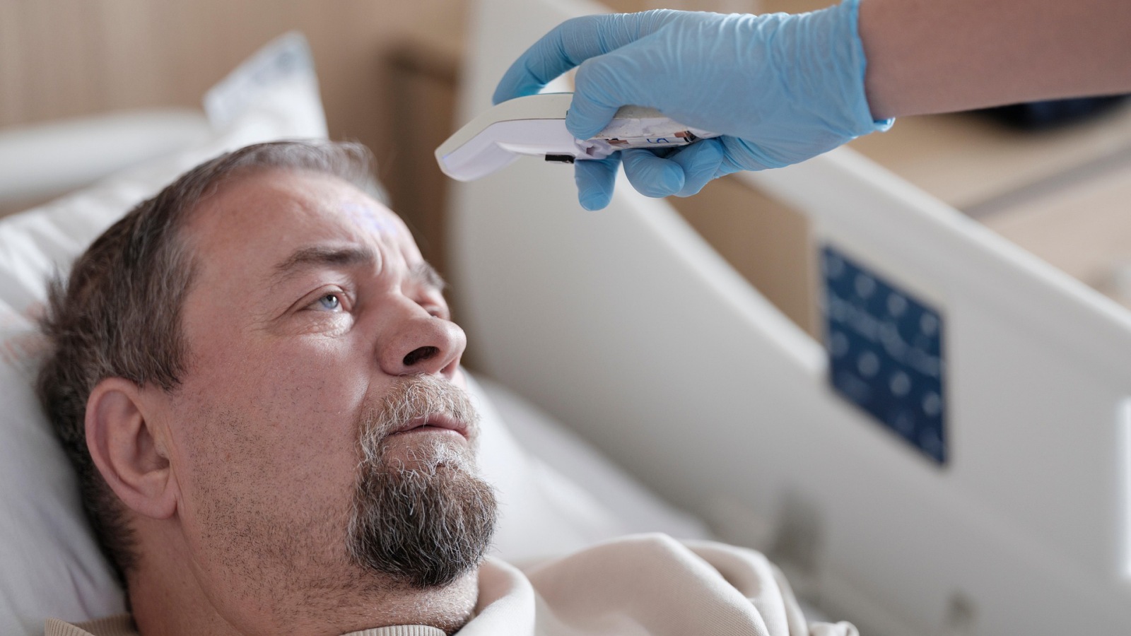 En patient får målt feber i sundhedsvæsenet.