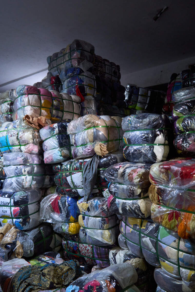 Genbrugstøj i paller tårner sig op i Kampala, Uganda.