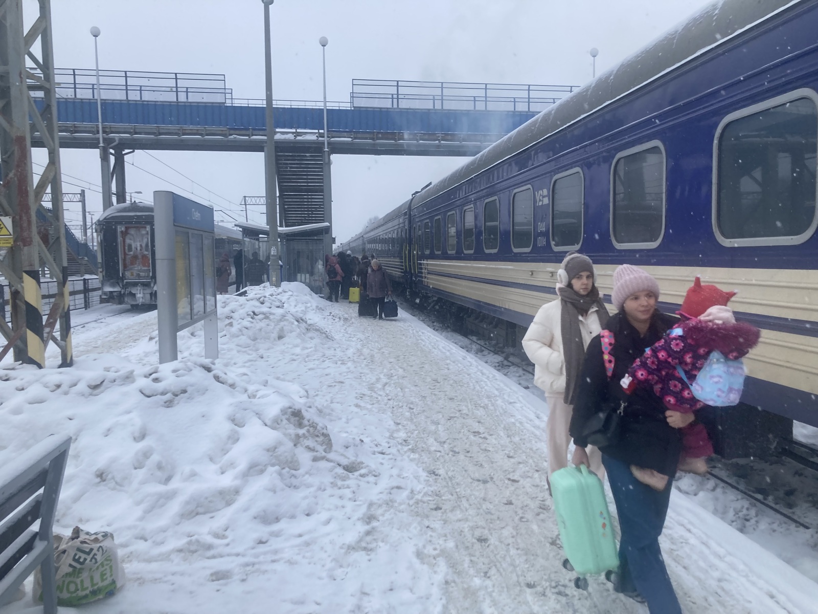 Passagerer på perronen i sne